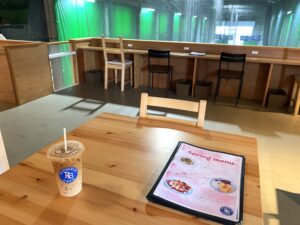 カフェスペース（メニューとカフェラテとカウンター遠景）